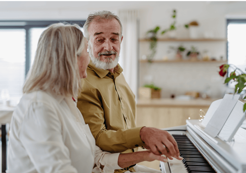 Pareja de adultos mayores tocan piano